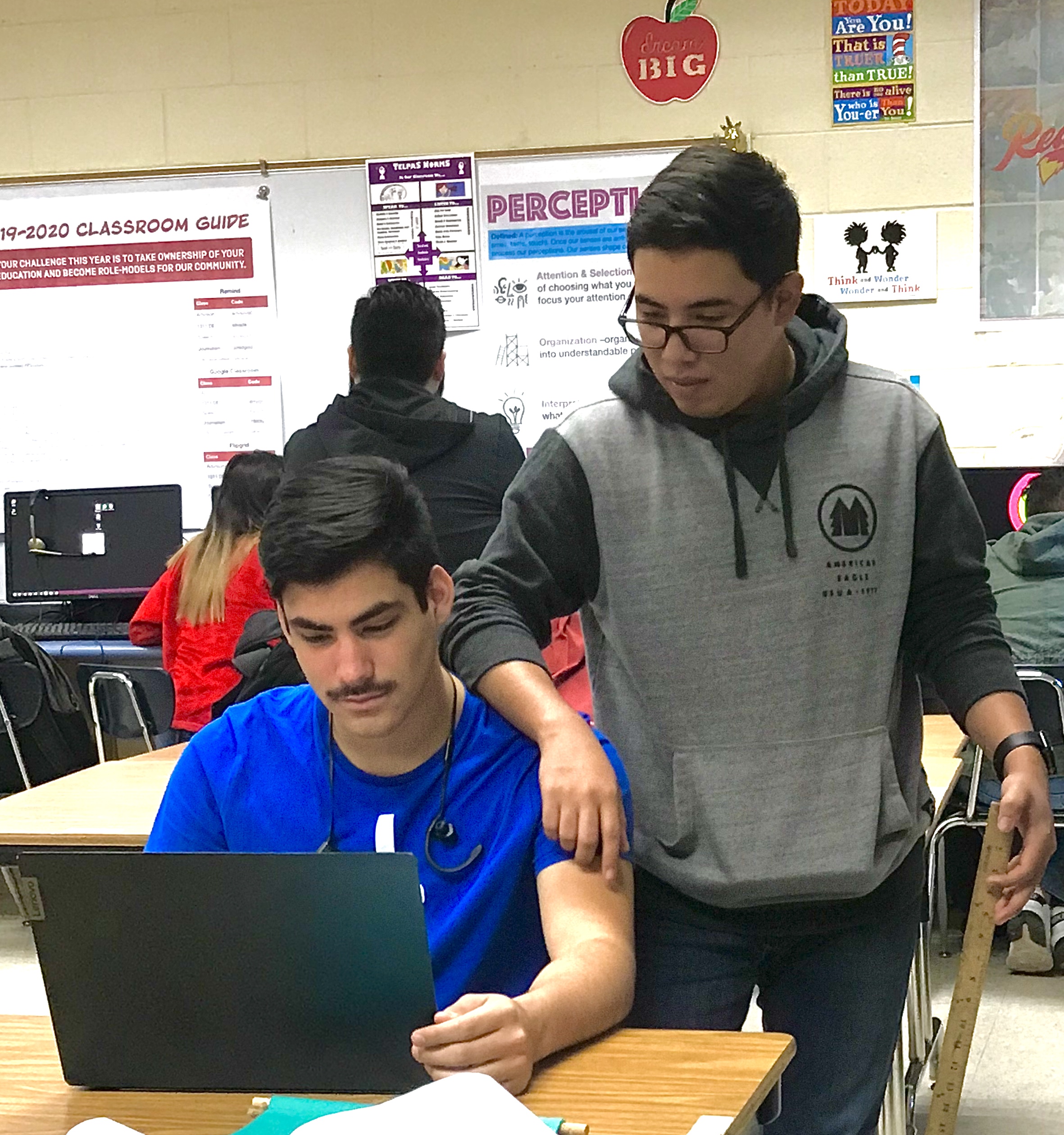 Two Carter students overlook their work on a computer side by side.