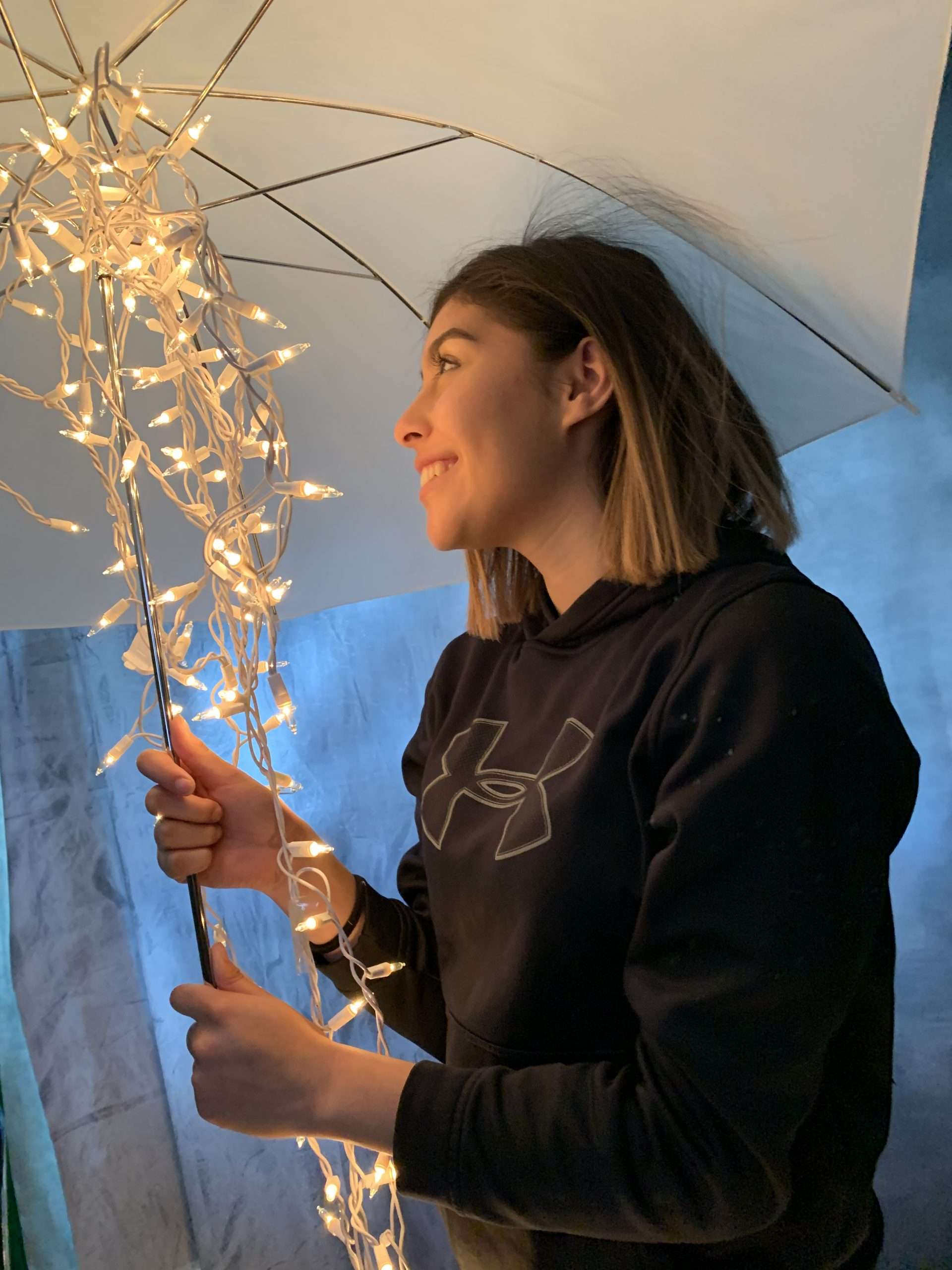 girl holding an umbrella with falling lights