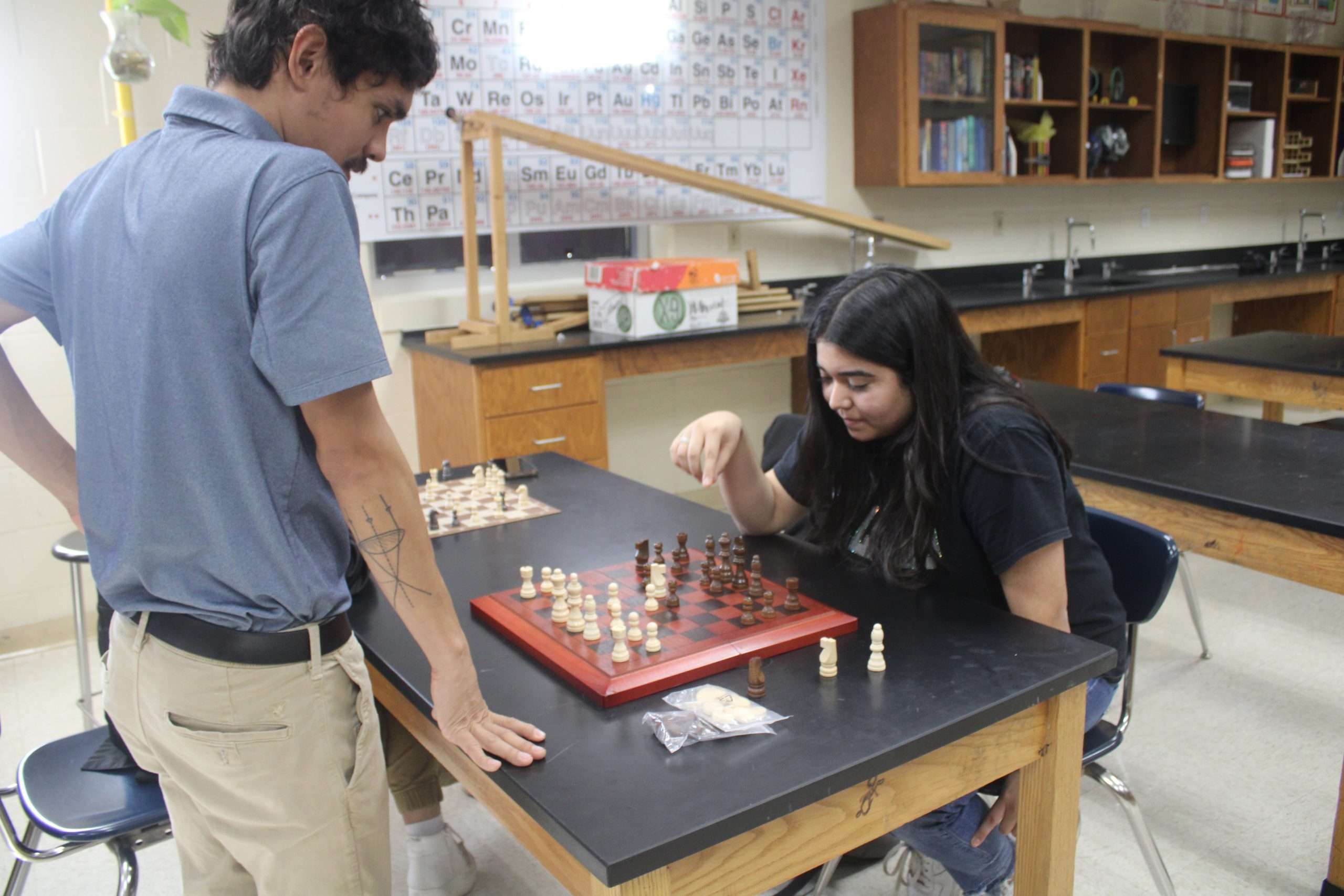 Teacher shows student how to play chess.